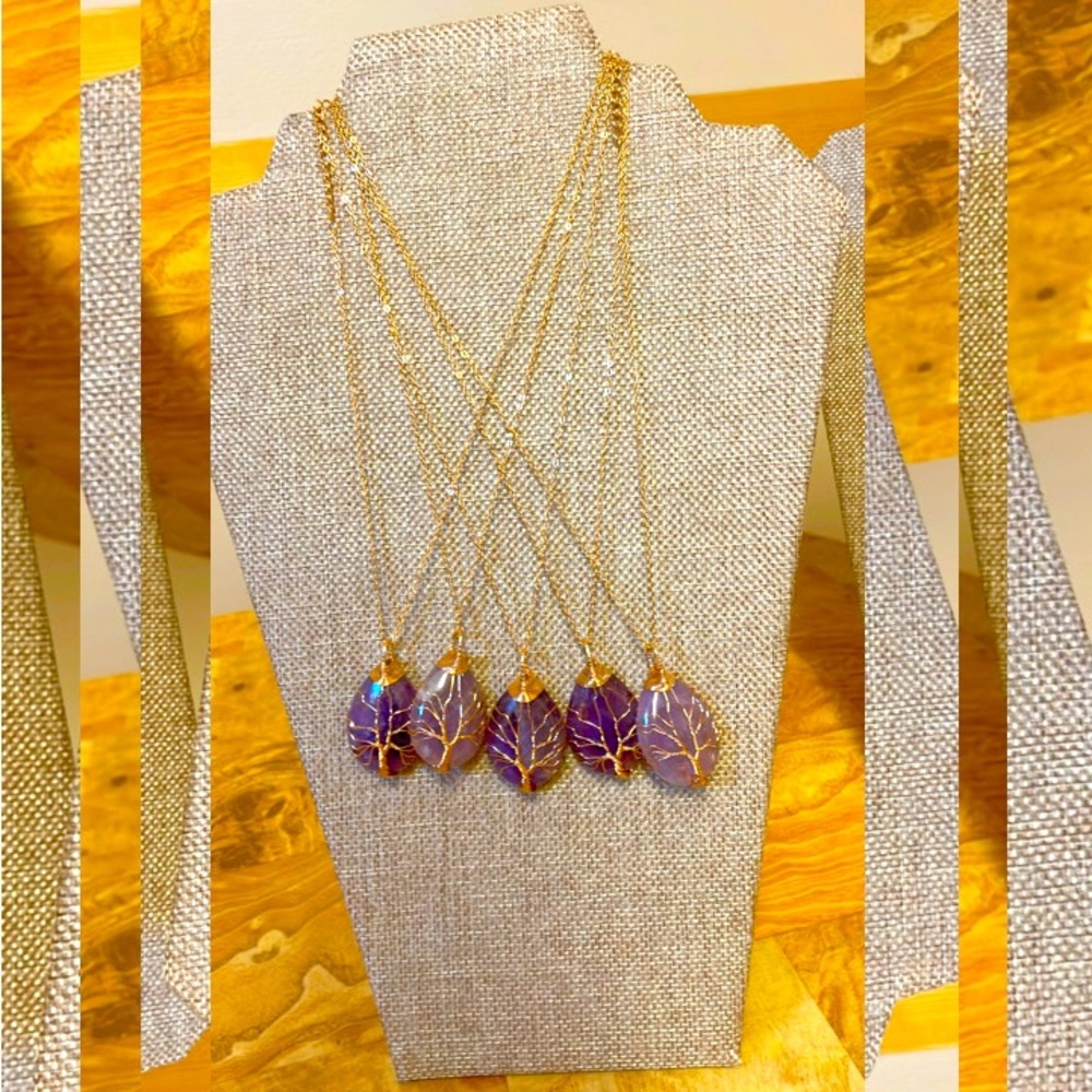 Amethyst necklaces with golden trim tree branches around them